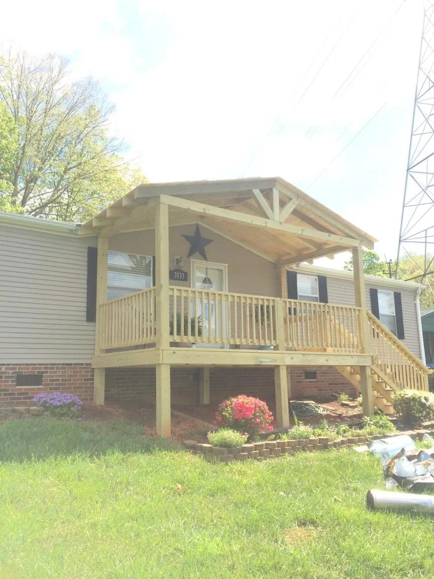 New gabled porch roof and deck railing added to a ranch home in Earlville